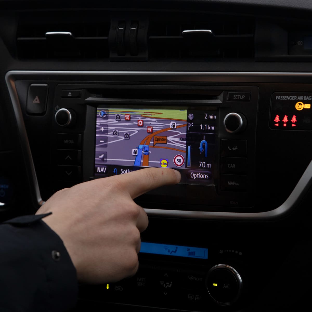 Navigaattorin räpläystä autossa.