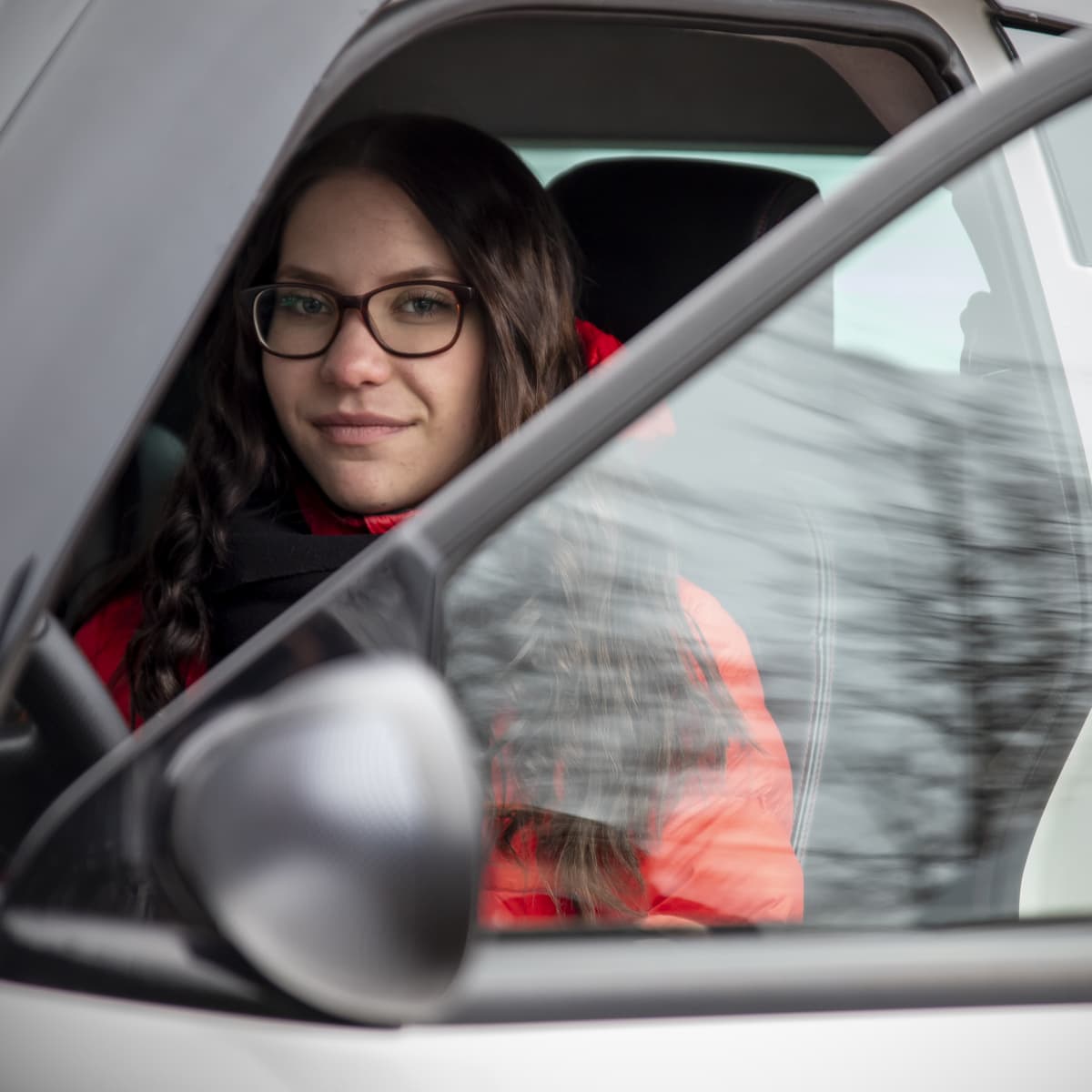 Juulia Ketola istuu mopoautossaan.