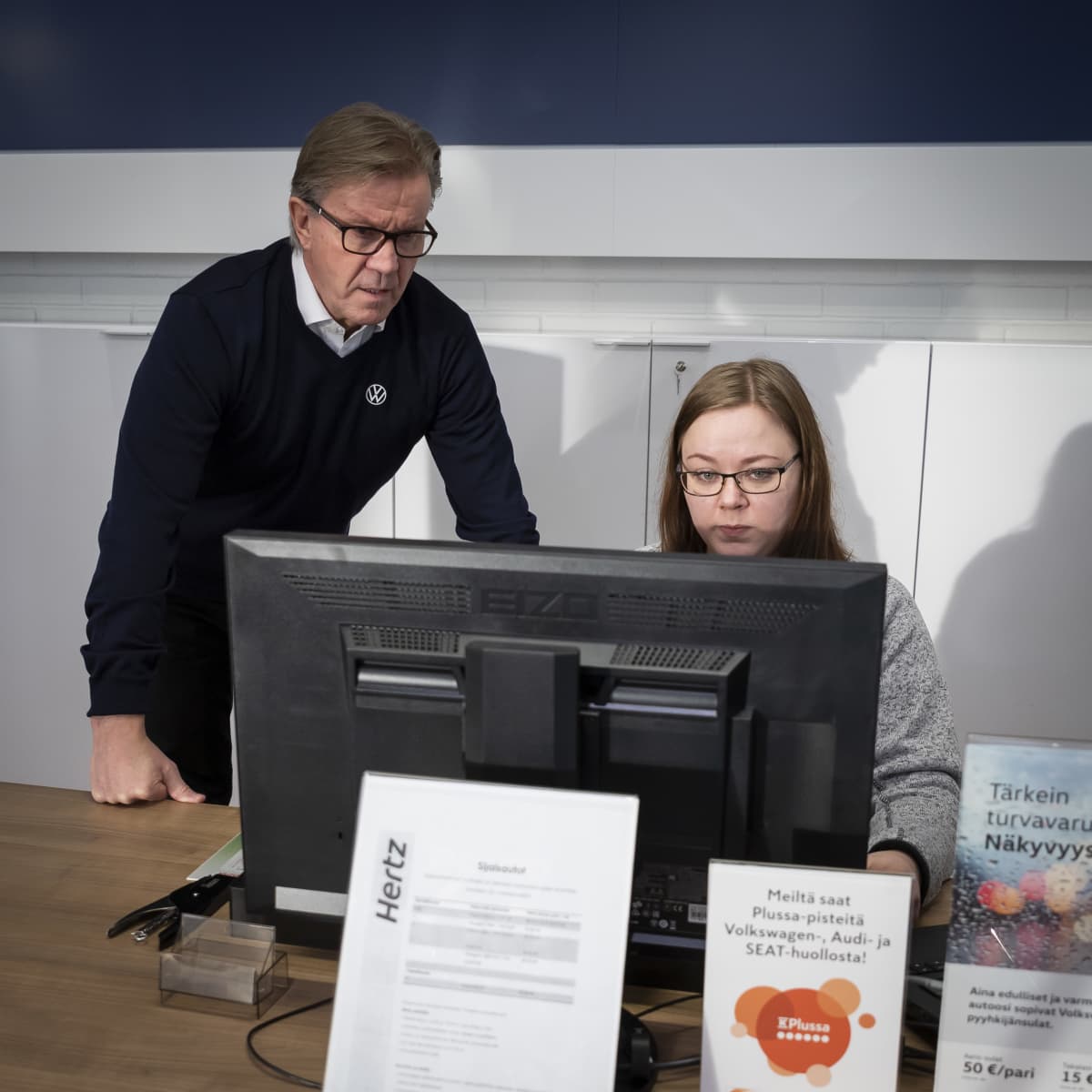 Vasemmalla Martti Kumpulainen tarkkailee vierestä, kun Terhi Takkinen tekee töitä tietokoneella.