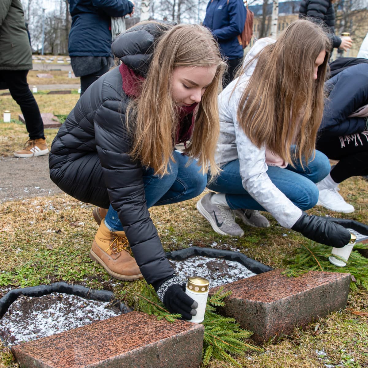Lukiolaisia laittamassa kynttilöitä Lappeenrannan Sankarihautausmaalla 80 vuotta talvisodan päättymisen kunniaksi.