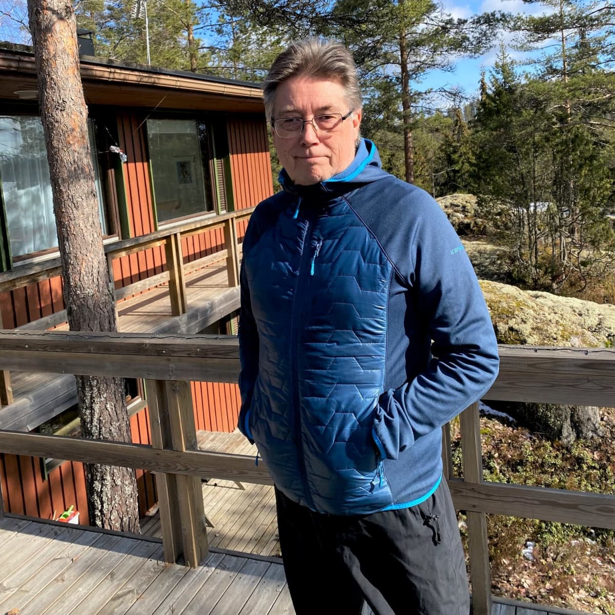 Ilkka Juva seisoo mökkinsä edustalla.