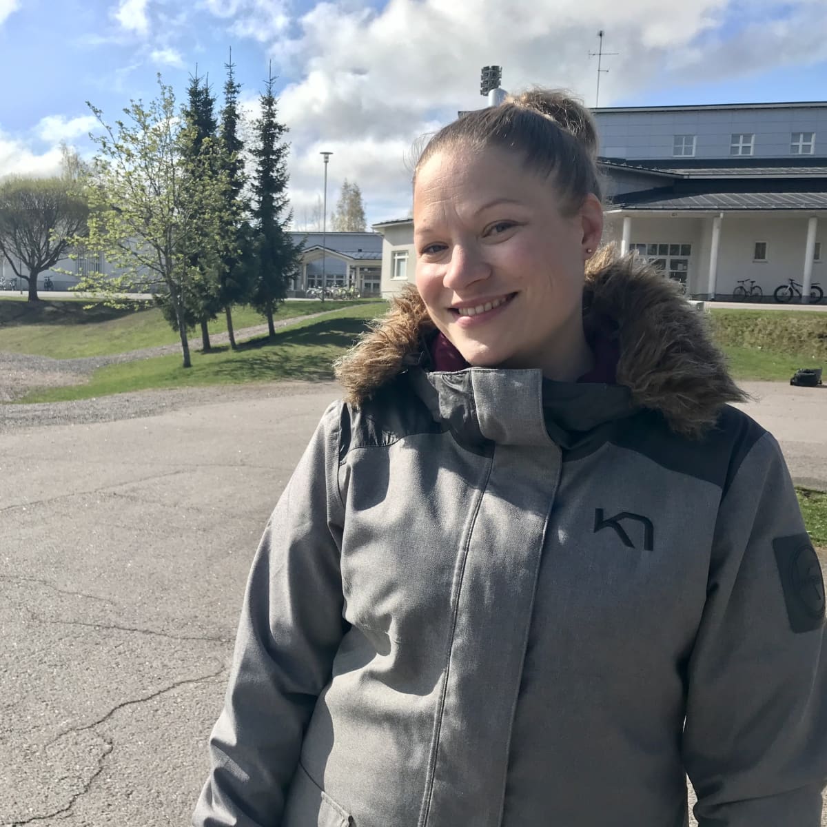 Anna-Kaisa Auvinen seisomassa koulun pihalla.