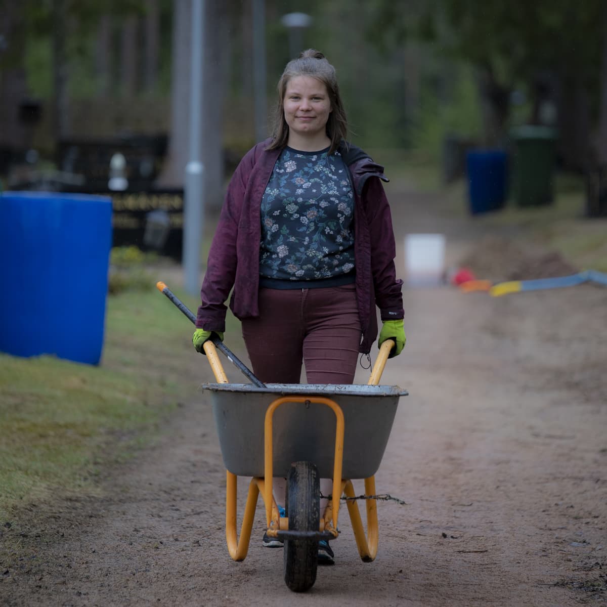 Oululainen Salla Tölli työntää kottikärryjä uudessa työssään puutarhurina.