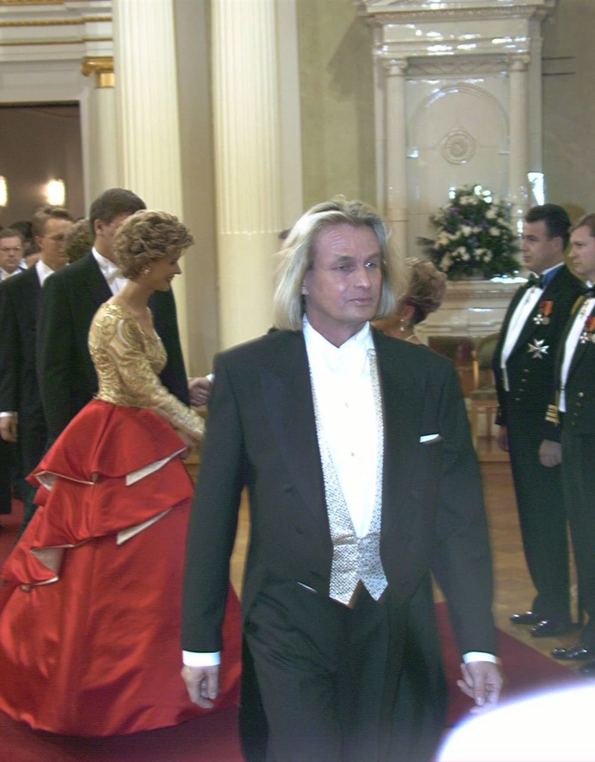 Tasavallan presidentin itsenäisyyspäivän vastaanotto Presidentinlinnassa 1996. Muotisuunnittelija Jukka Rintala, taustalla Kaija Pöysti Rintalan suunnittelemassa iltapuvussa.