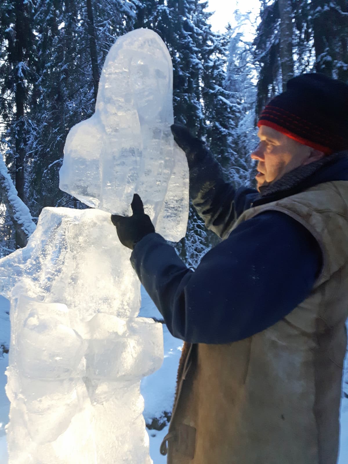 Mies nostaa irronnutta jääveistoksen osaa takaisin paikoilleen.