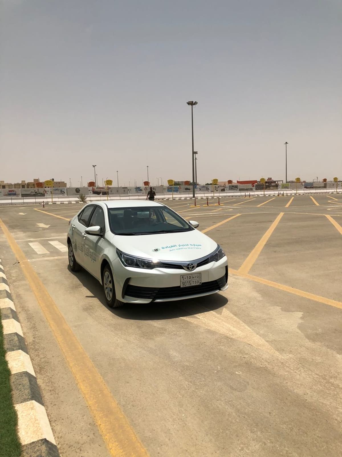 Saudiarabialainen ajokoe, jossa virkailija seisoi auton ulkopuolella.