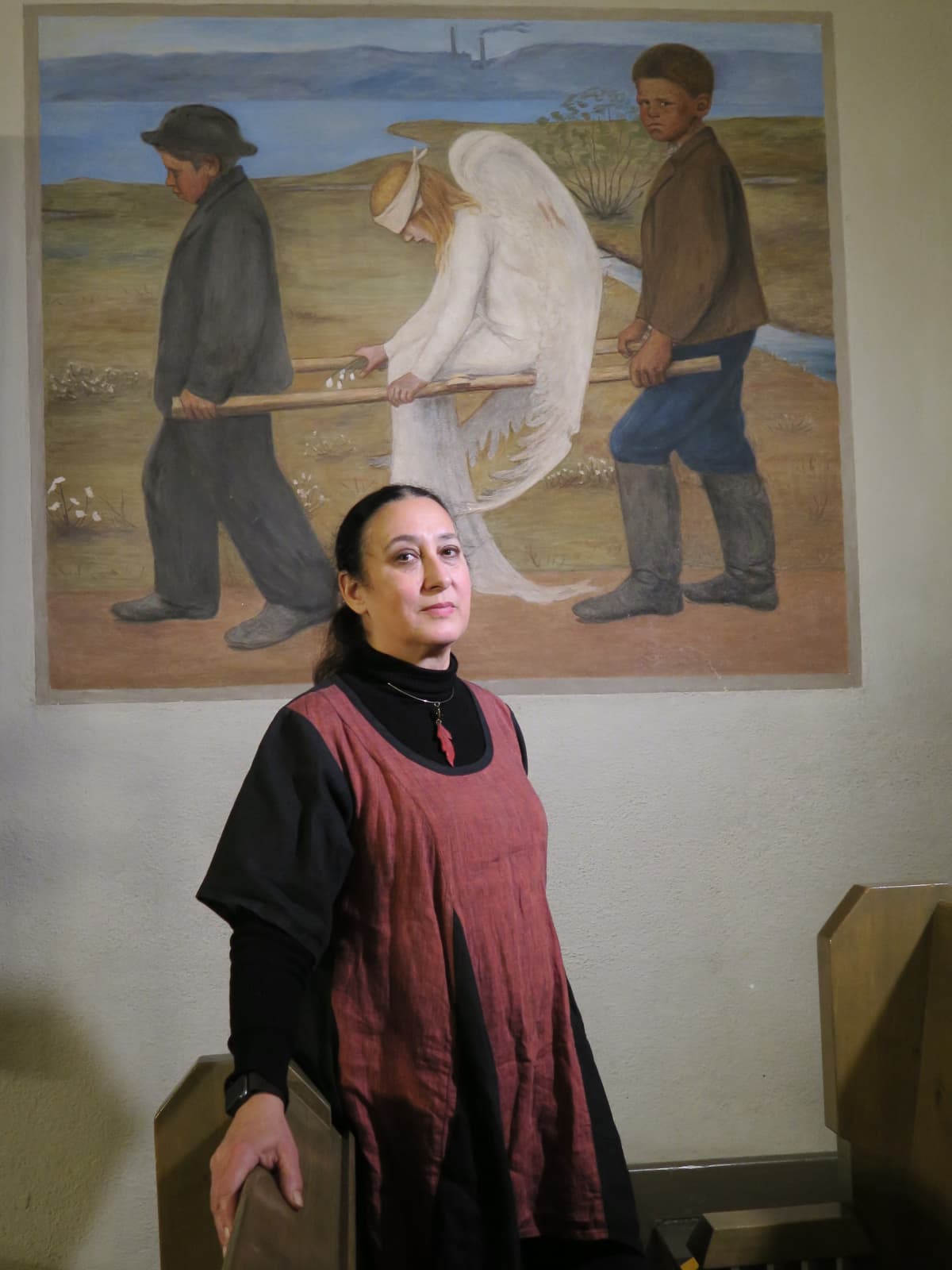 Kuoronjohtaja Debra Gomez-Tapio Hugo Simbergin "Haavoittutut enkeli" -maalauksen edessä Tuomiokirkossa.