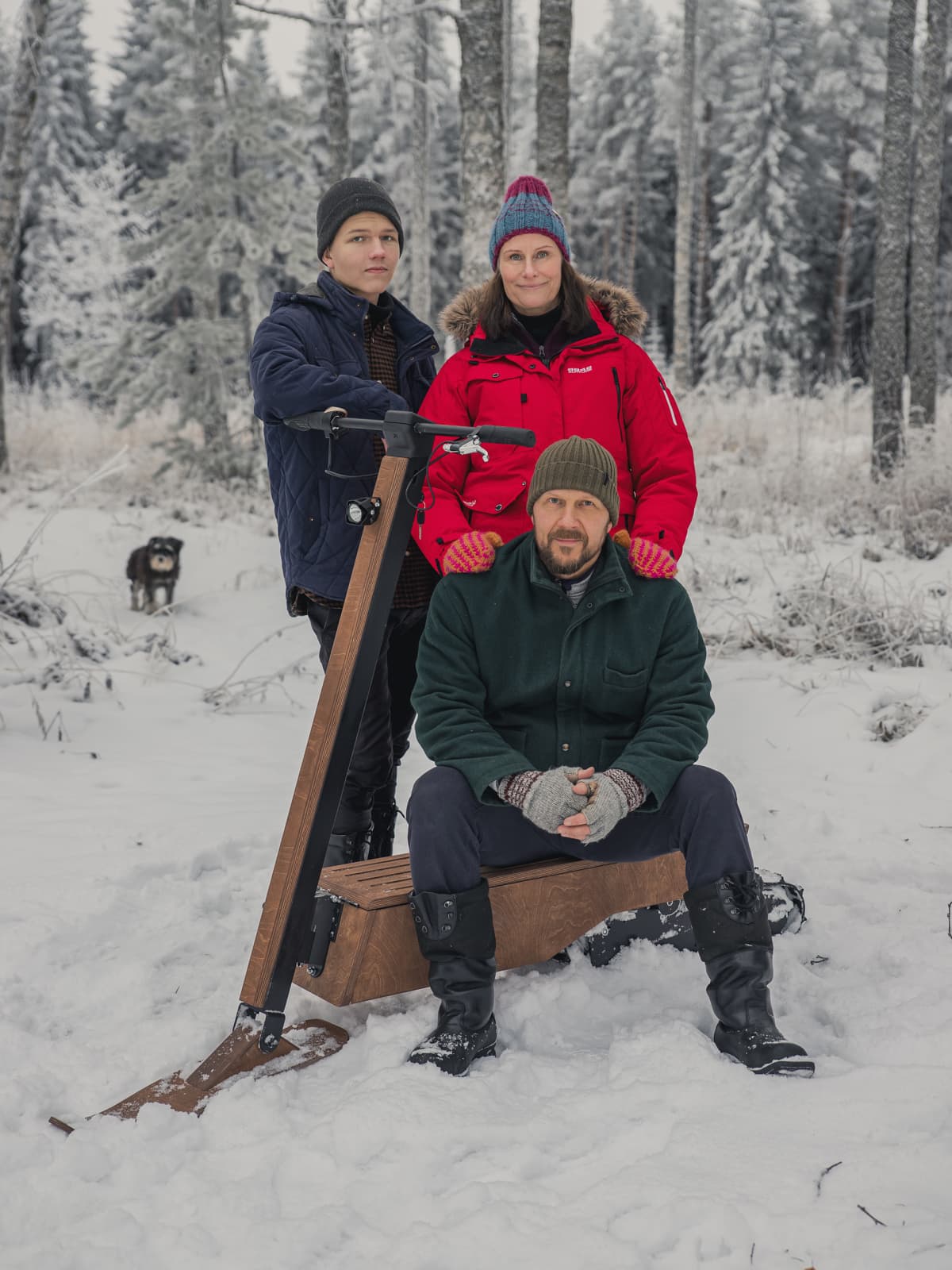 Kauppisen perhe poseeraa sähkölumiskootterin vierellä.