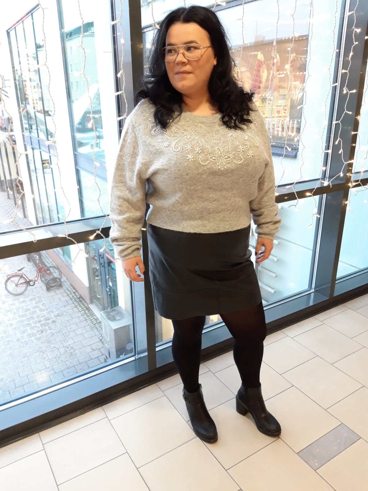 Sanna Koskela pukeutui mustiin sukkahousuihin, mustaan hameeseen ja harmaaseen paitaan.