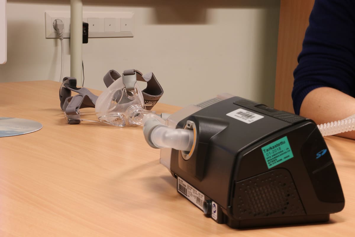 CPAP-laitteen osat ovat kompressori ja kasvoille asetettava hengityslaite.
