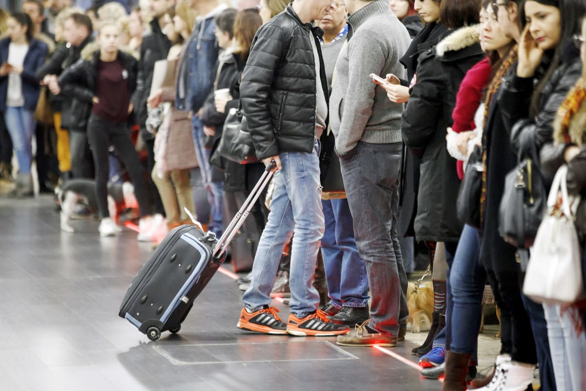 Matkustajat jonottavat lentoasemalla.
