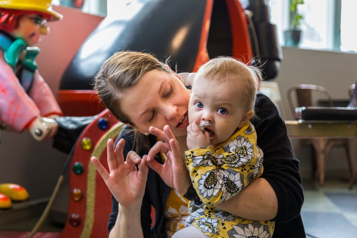 Äiti ja 1-vuotias vauva kommunikoivat viittomalla.