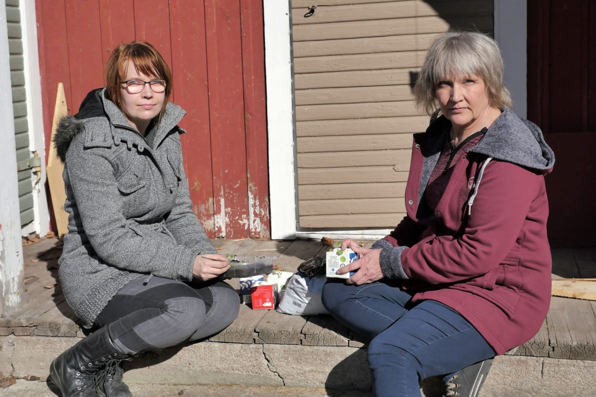 Emmi ja Anneli istuvat piharakennuksen portailla
