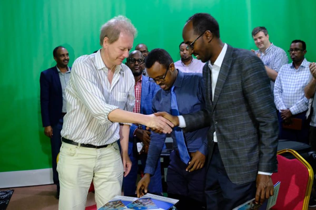 Vikesin koordinaattori Peik Johansson, Somalian viestintäministeriön kansliapäällikkö Abdirahman Yusuf al-Adala ja Somalian kansallistelevision johtaja Liban Abdi Ali virallisissa tunnelmissa.