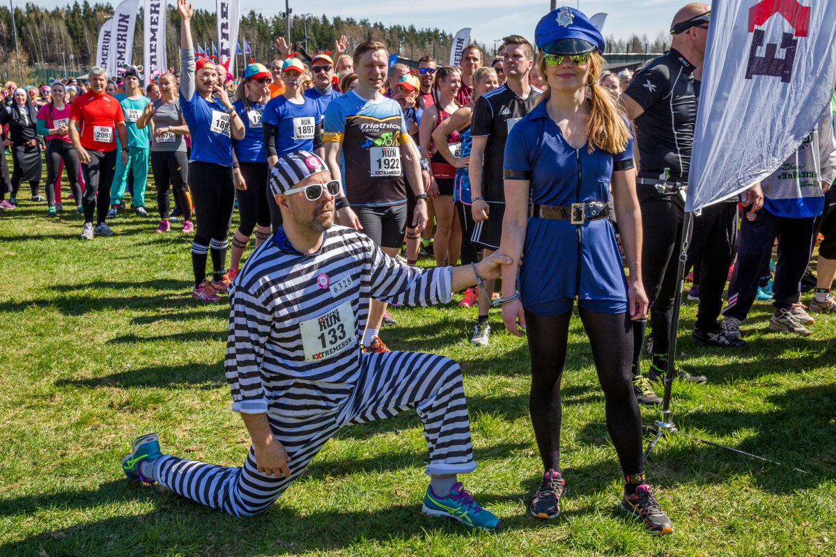 Rosvoksi pukeutunut mies polvistuu poliisiksi pukeutuneen naisen eteen yleisötapahtumassa.