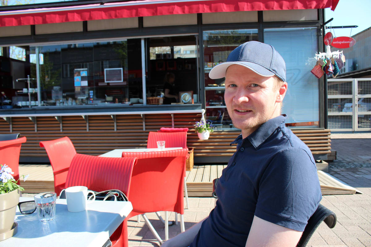 Pelinjohtaja Petri Pennanen istuu kahvilan pöydän ääressä.