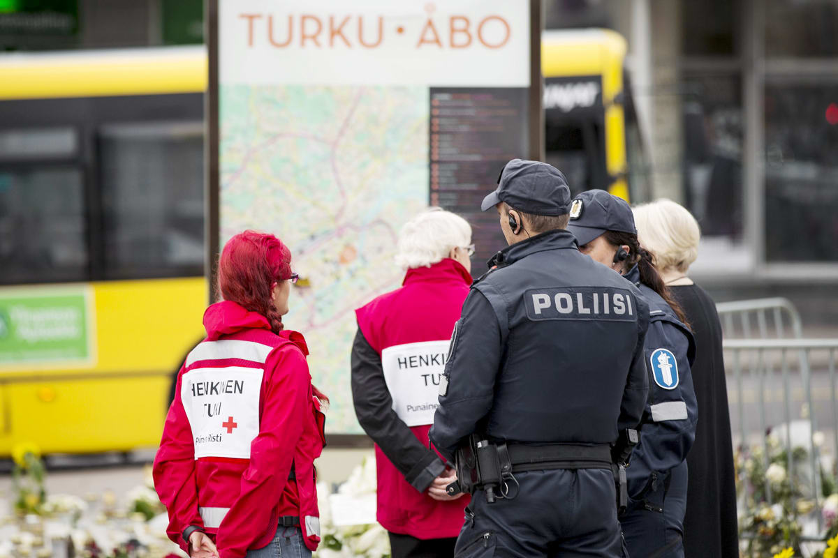 Poliisipartio ja SPR:n vapaaehtoisia Turun kauppatorilla puukotusten uhrien muistopaikalla.