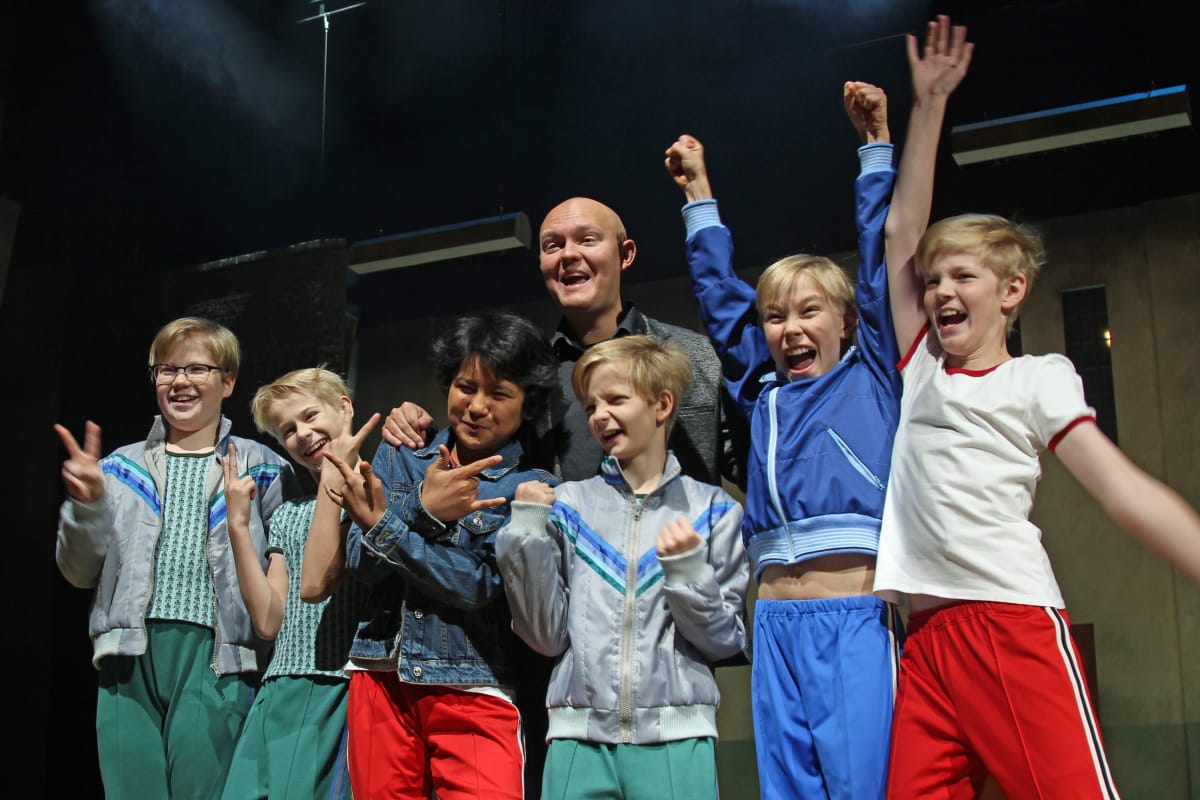 Billy Elliot -musikaalin pääosien esittäjät poseeraavat lavalla ohjaaja Samuel Harjanteen kanssa