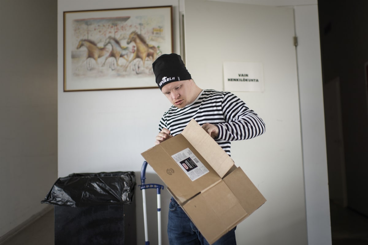 Samuli Kivinen taittelee pahvilaatikoita.