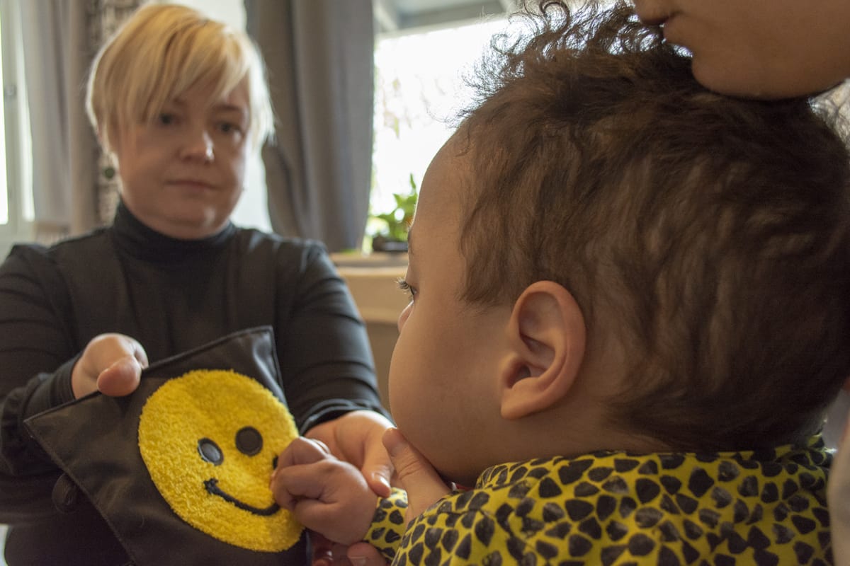 Aino Odedeyi esittelee koskettelukirjaa Olavi-pojalleen.