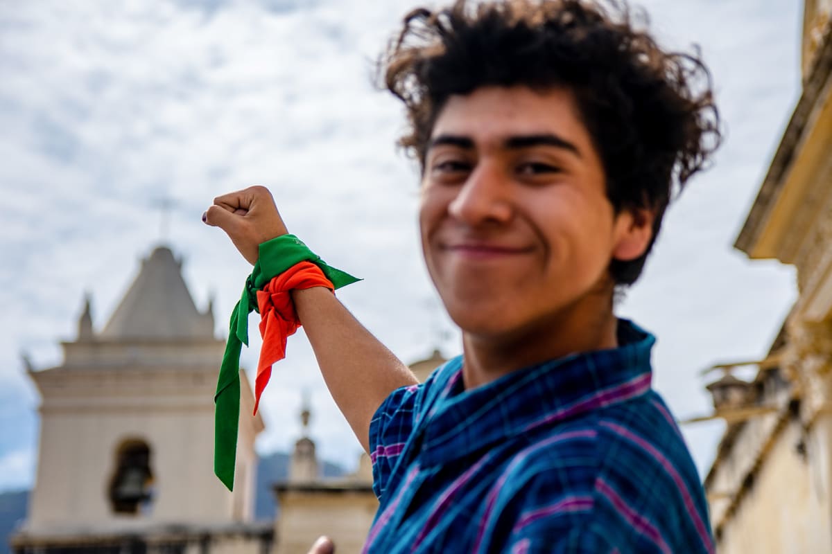 Enzo Veleizán on sitonut käteensä aborttioikeutta vaativan kampanjan vihreän tunnushuivin sekä oranssin liinan.