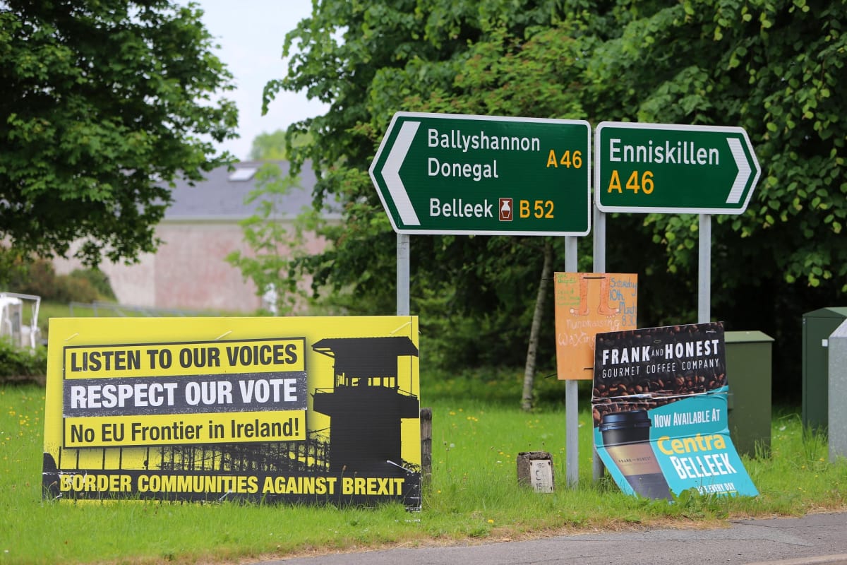 Tien vieressä on kyltti, jossa vastustetaan kovaa EU-rajaa Irlantiin. Vieressä on tienviitat vasemmalle Ballyshannoniin, Donegaliin ja Belleekiin sekä oikealle Enniskilleniin.