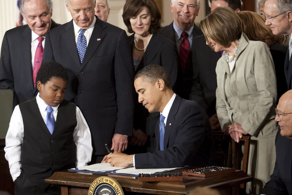 Kuvassa presidentti Barack Obama allekirjoittaa lakipaperia terveydenhuoltouudistuksesta.