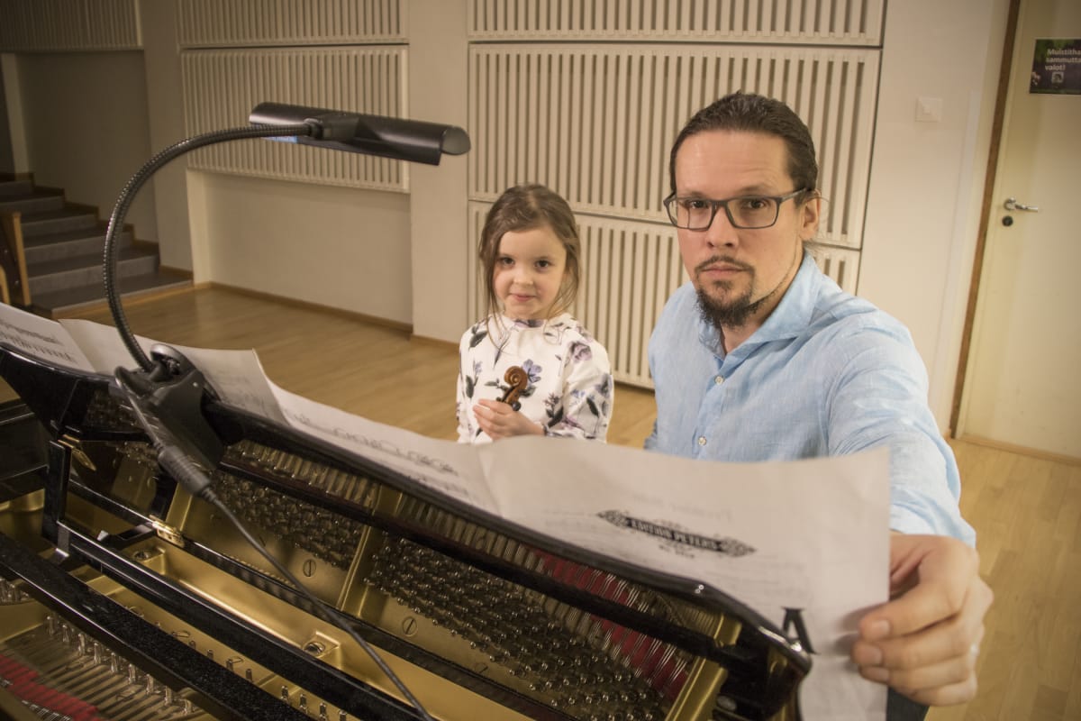 5-vuotias tyttö isänsä kanssa flyygelin ääressä.