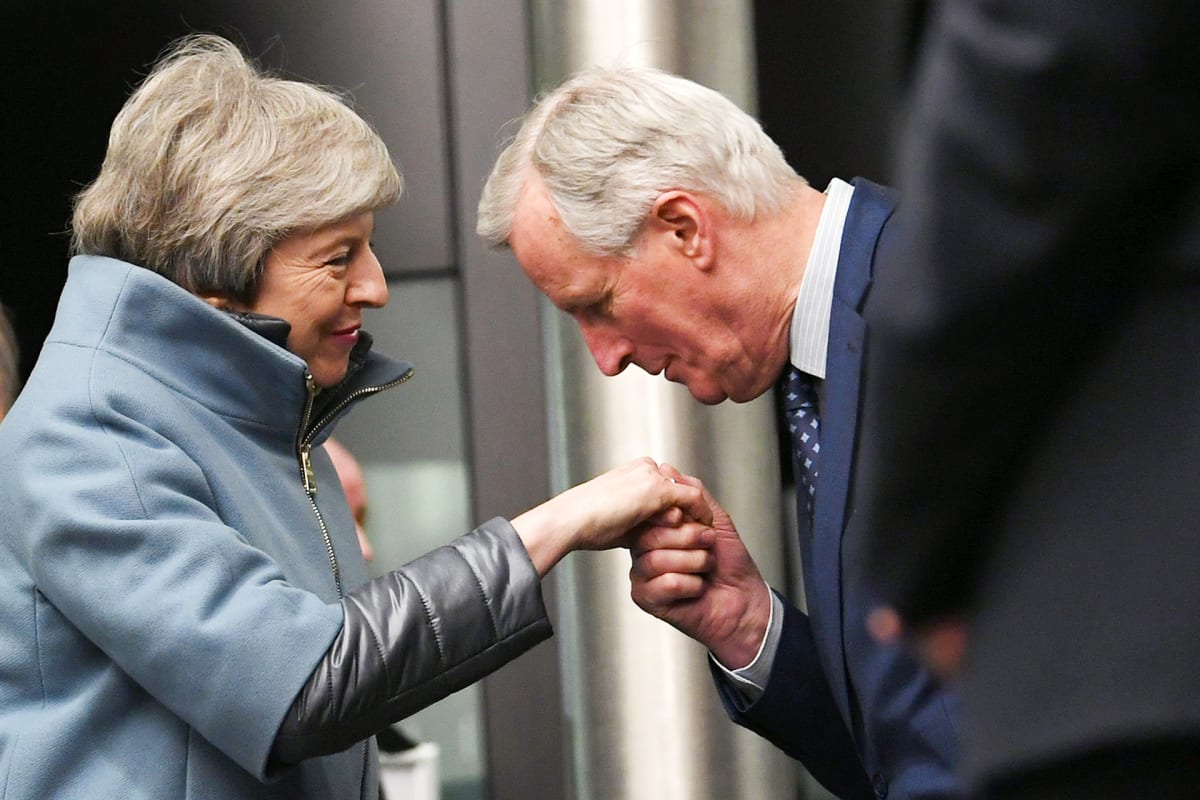 EU:n brexit-pääneuvottelija Michel Barnier suutelee Theresa Mayn kättä.