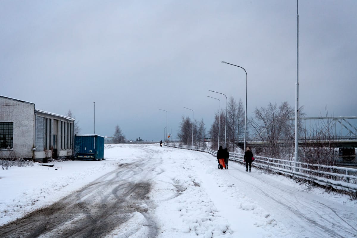 Naisia kävelee tiellä, vieressä virtaa joki.