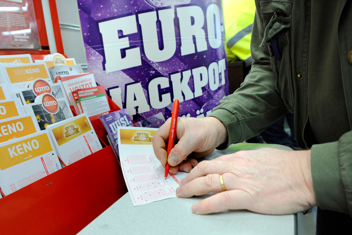 Mies täyttää Eurojackpot-kuponkia.