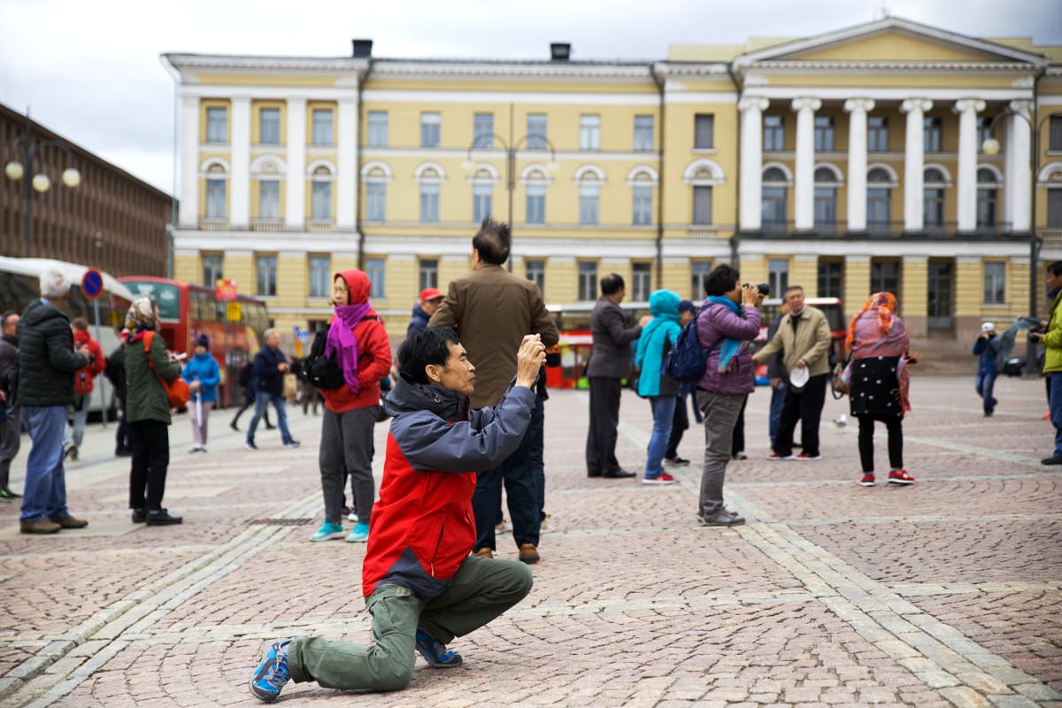 Kiinalainen turisti kuvaamassa senaatintorilla