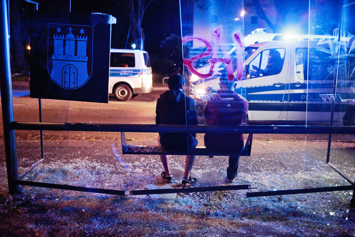 Kaksi miestä rikotulla bussipysäkillä-