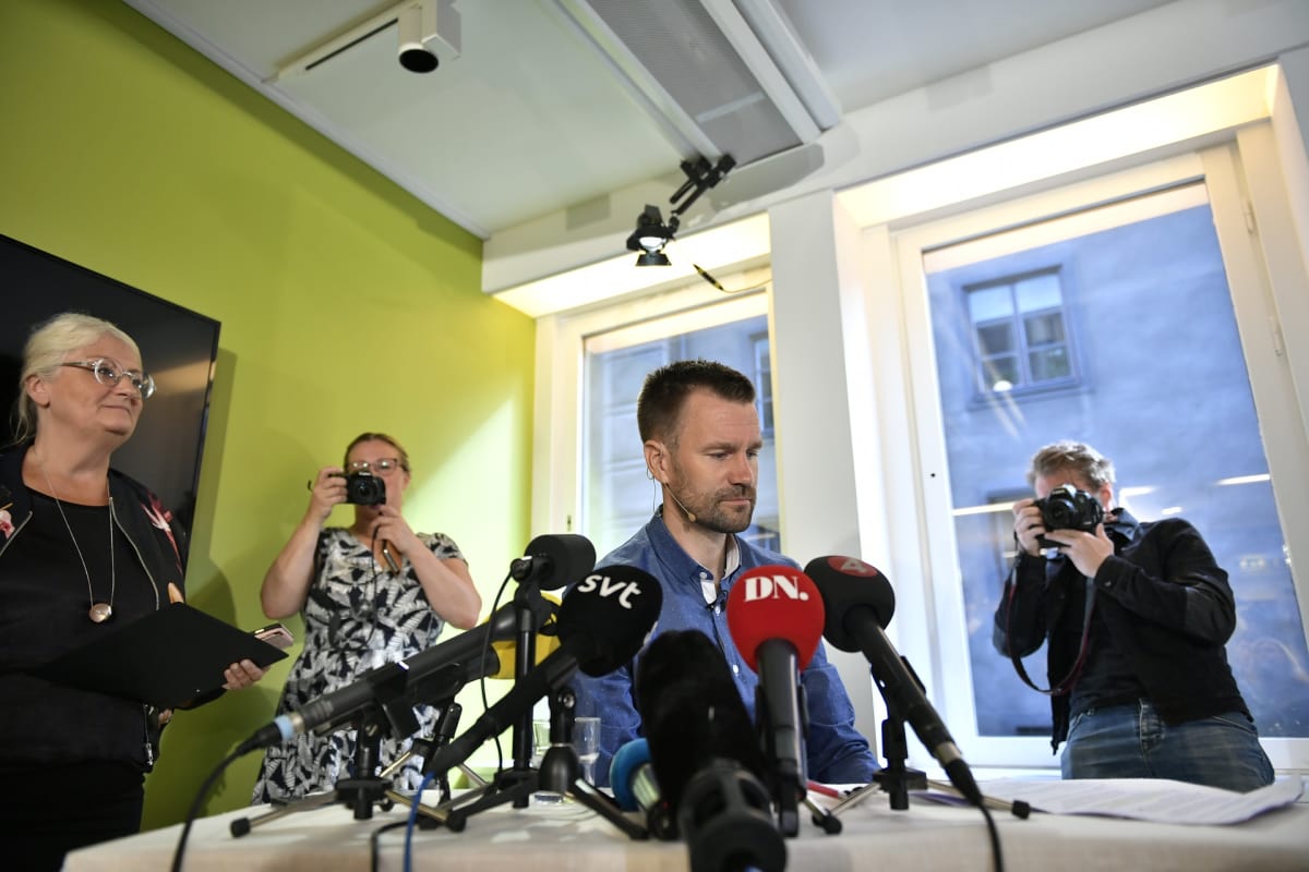 Gustafsson mikrofoneja edessään, kuvaajia ympärillään.