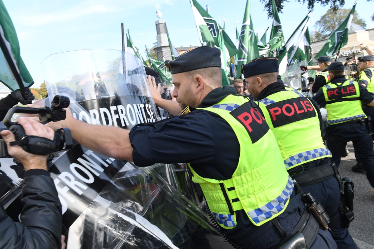 Poliisi estää mielenosoittajia marssimasta kielletylle kaduille.