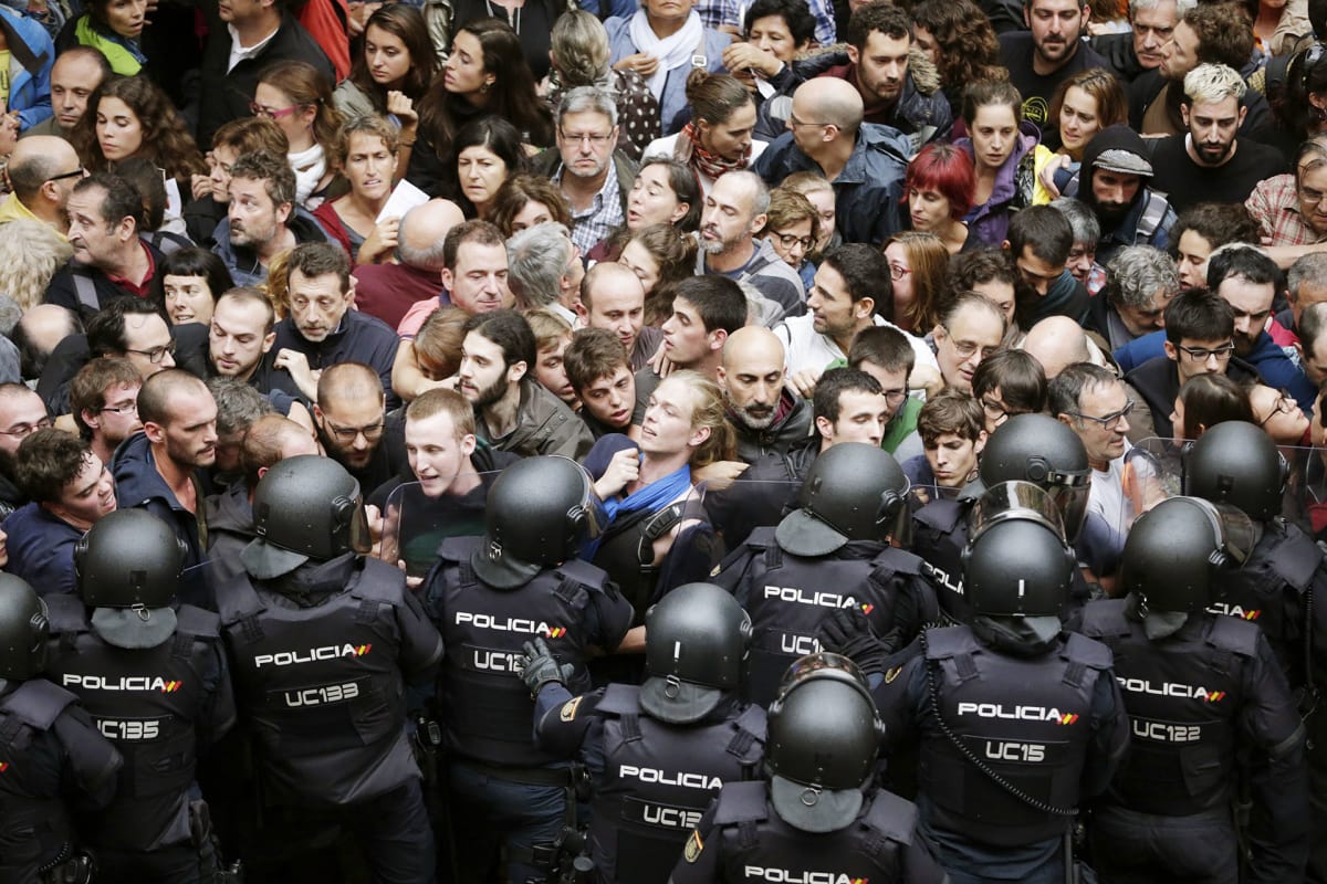 Mellakkapoliisit ja aktivistit ottavat yhteen äänestyspaikkana toimivan koulun edustalla Barcelonassa.