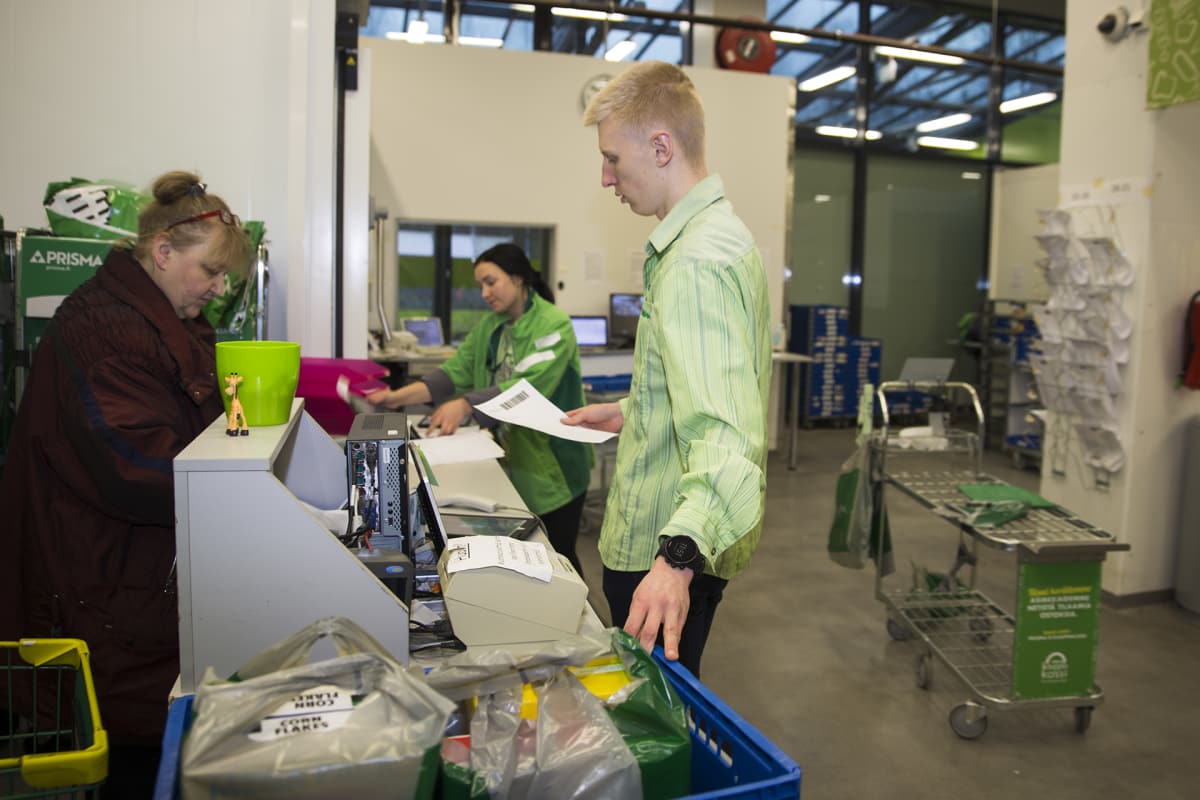 Työntekijä palvelee verkkokauppaostoksia hakemaan tullutta asiakasta Kannelmäen Prismassa