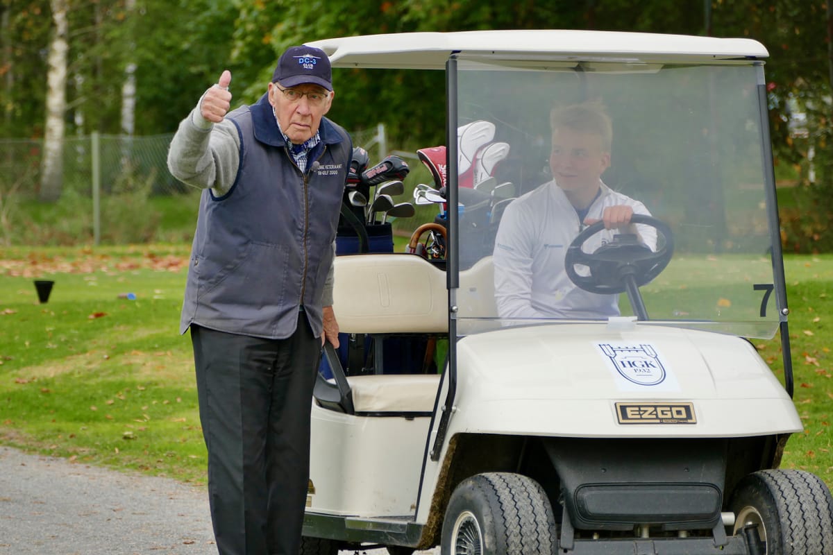 Mauri Maunula ja Rasmus Harmanen istuvat golf-autossa.