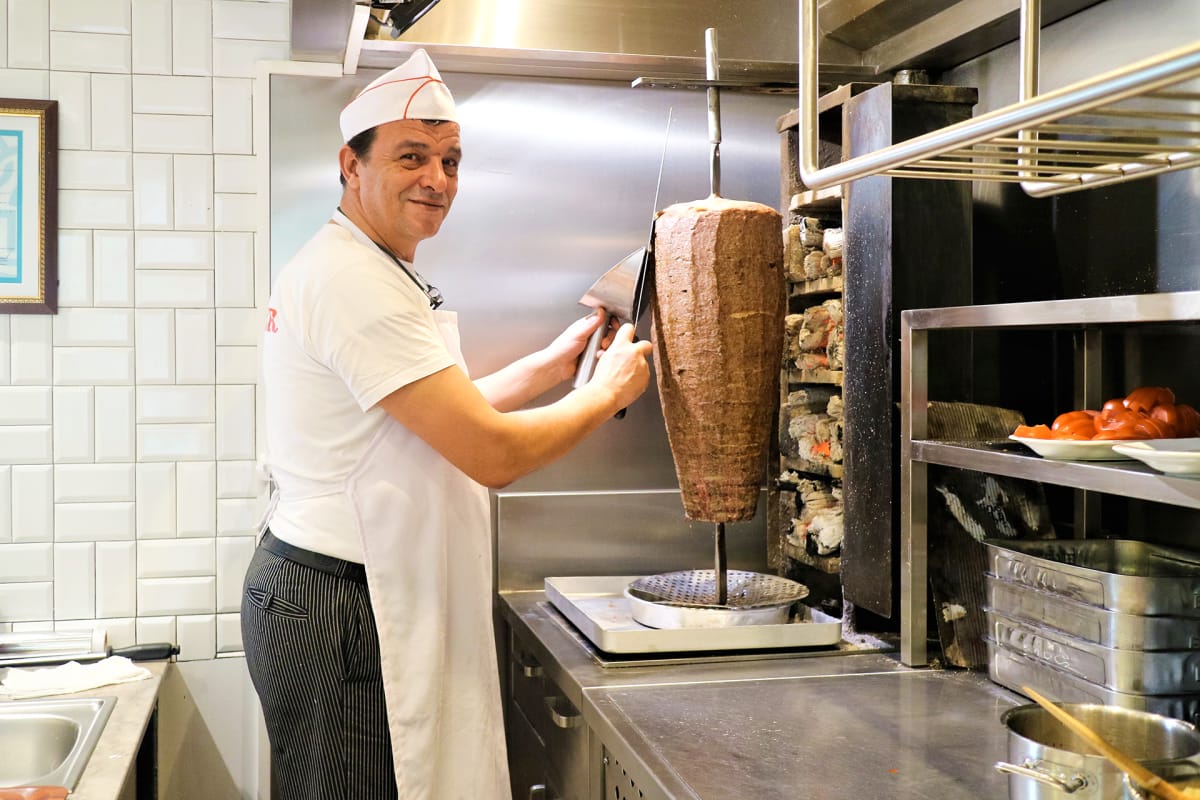 Pystyssä pyörivä kebabvarsi kehitettiin, jotta rasvaa ei valuisi tuleen ja käry vähenisi.