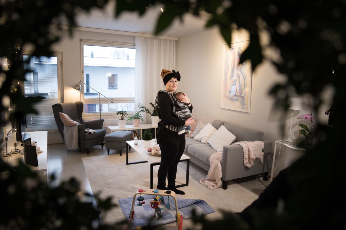Iida Åfeldt vauva sylissä olohuoneessaan.