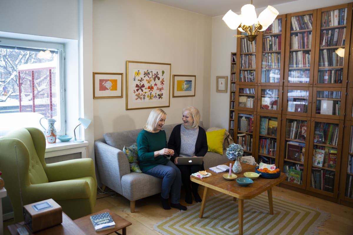Tiina ja Sinikka Nopola työskentelevät sohvalla.