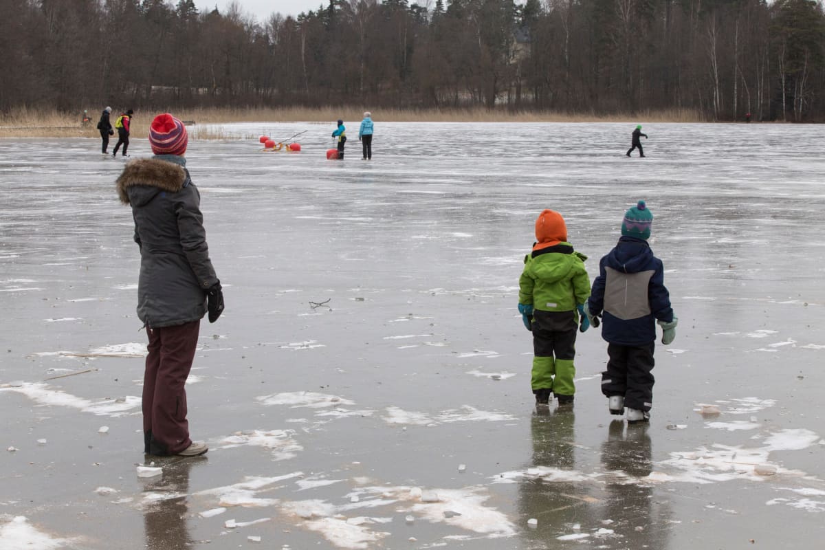 Ihmisiä järven jäällä.