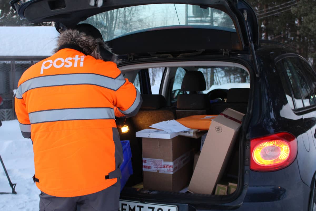 Sevettijärvi-Näätämö alueen posteja ja paketteja lajitellaan Kaamasessa. Kuvassa selin postinjakaja Teijo Paadar.