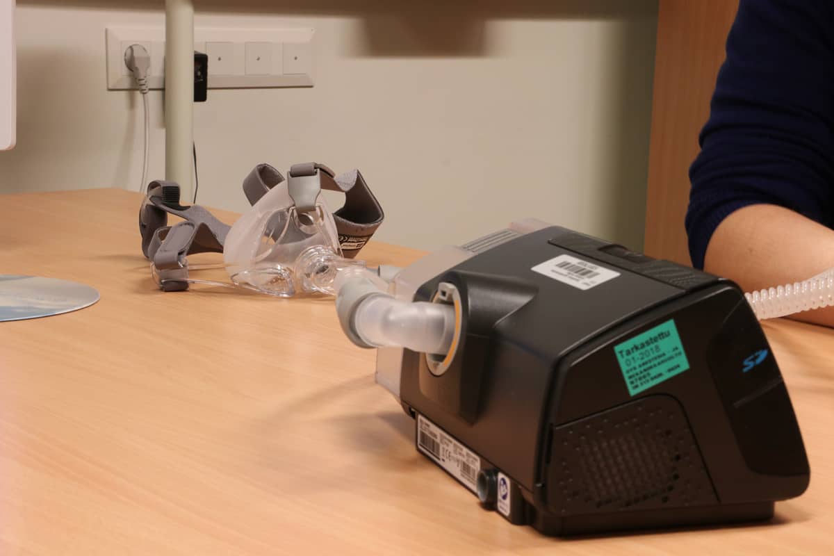 CPAP-laitteen osat ovat kompressori ja kasvoille asetettava hengityslaite.