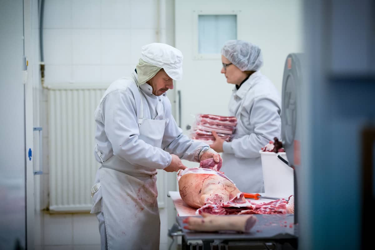 Lihanleikkaaja Mika Kujanmäki (vas) ja maatilayrittäjä Reetta Kivi (takana) lihanleikkuutiloissa, Sikala-tilateurastamo Kiven Säästöpossu, Karkkila, 14.2.2018.