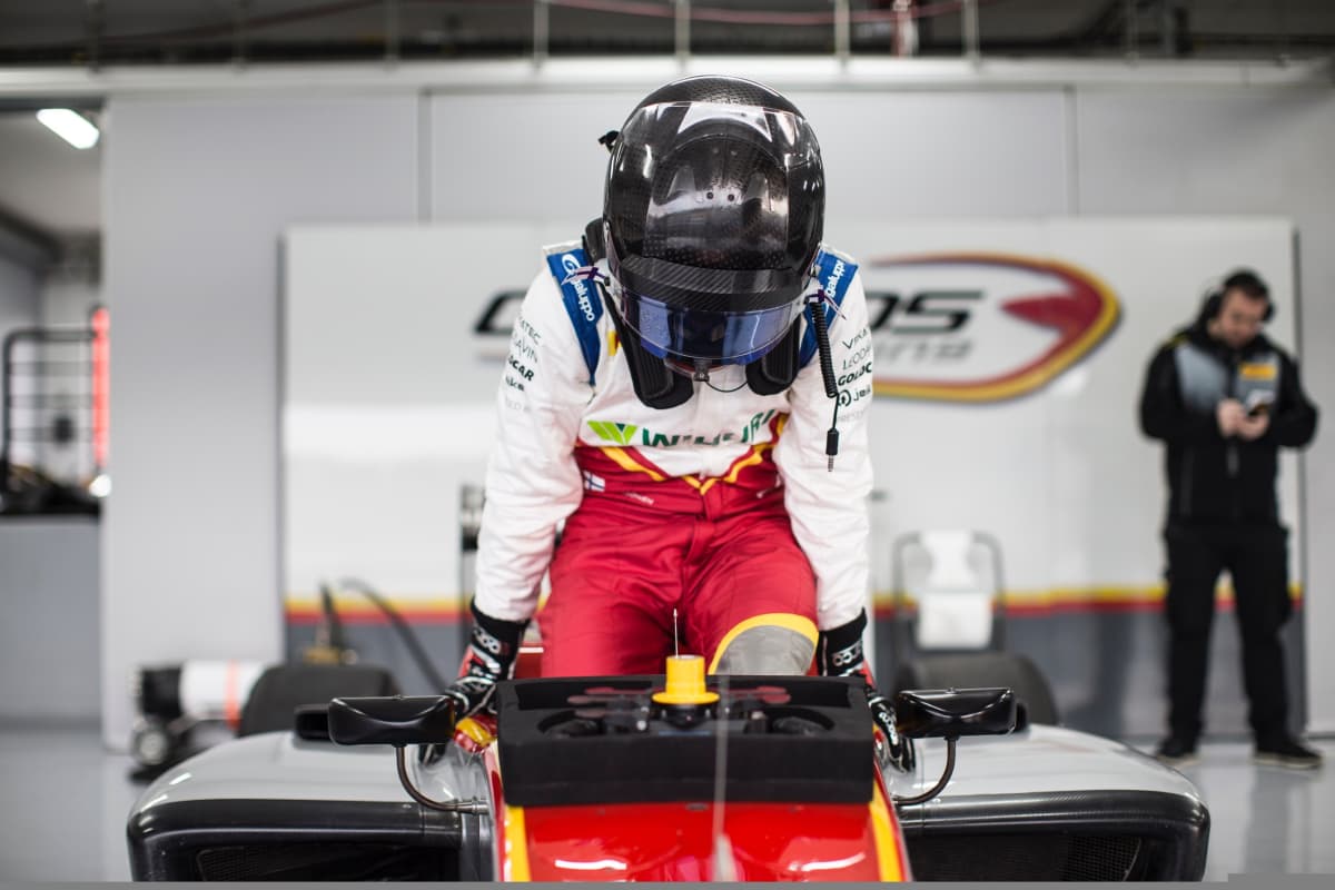 Simo Laaksonen istumassa formula-autoon.
