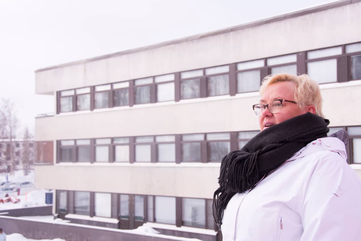 Tarja Kovalainen seisoo vanhan työpaikkansa edessä.