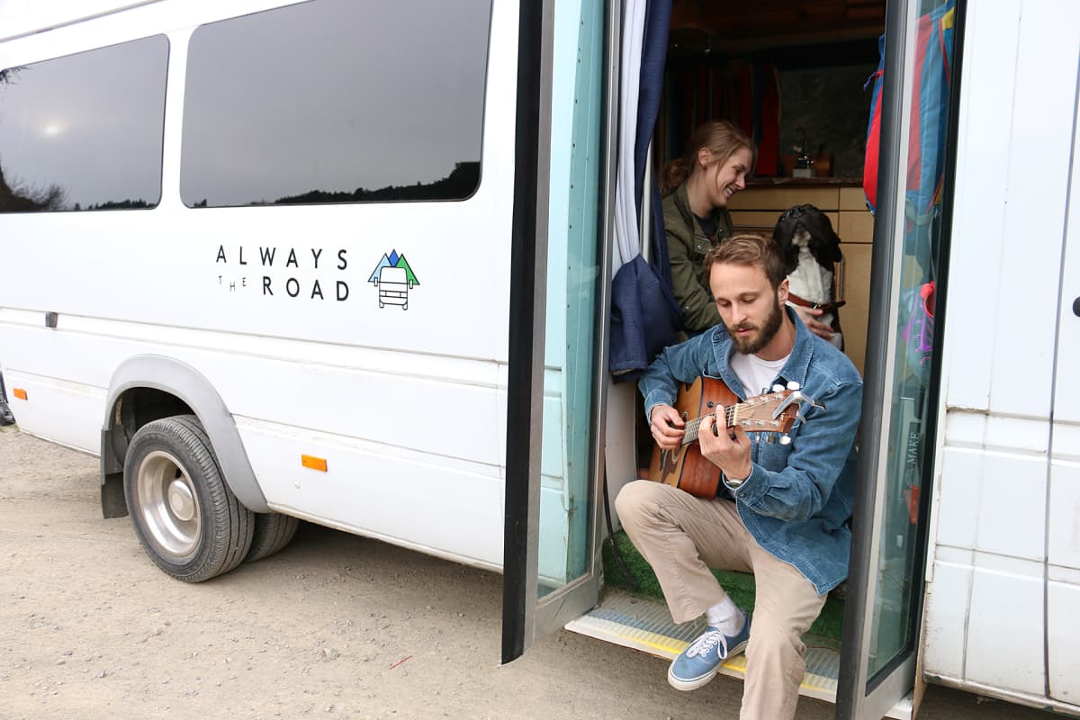 nainen, koira ja kitaraa soittava mies minibussilla