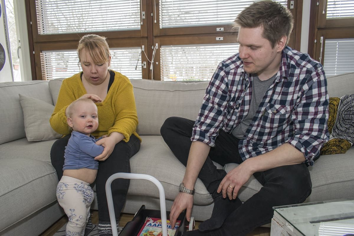 Äiti, lapsi ja isä ovat yhdessä sohvan luona