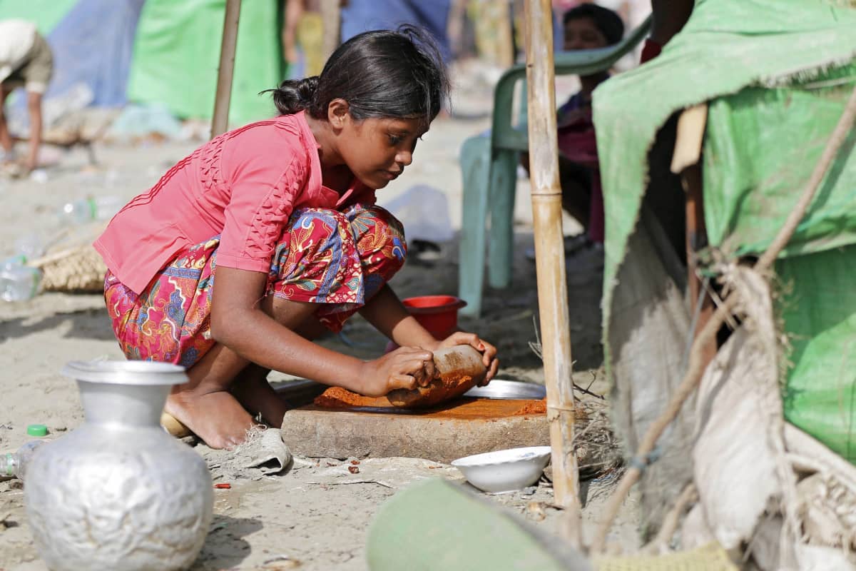 Rohingya-tyttö laittaa ruokaa.